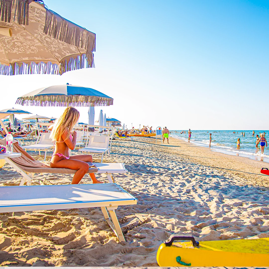 spiaggia a Riccione con donna bionda seduta sulla sdraio