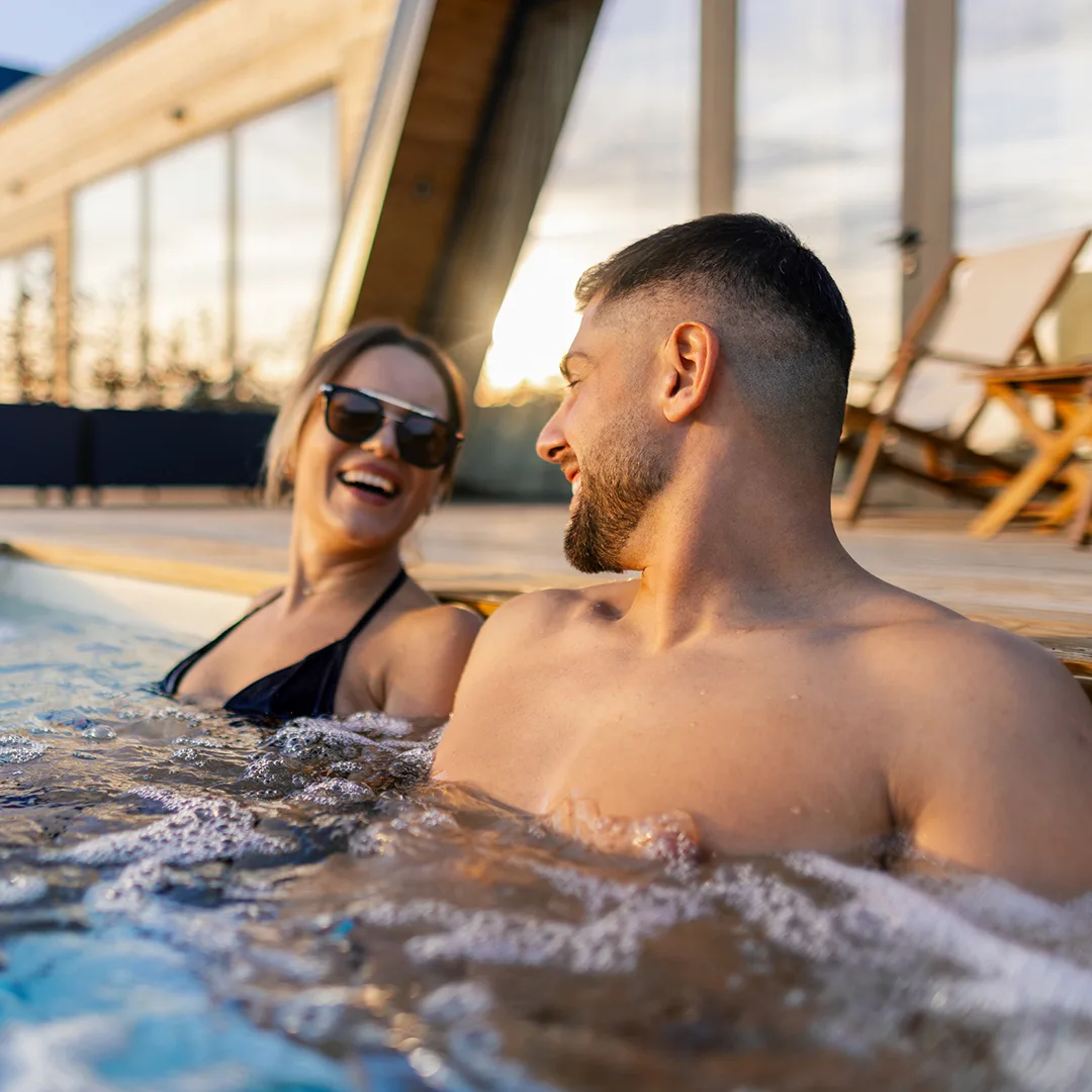 un ragazzo e una ragazza che ridono a bordo di un idromassaggio